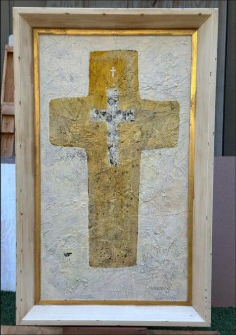 Gold cross on textured ground